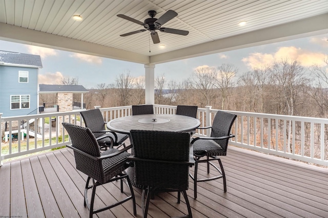 deck at dusk featuring ceiling fan