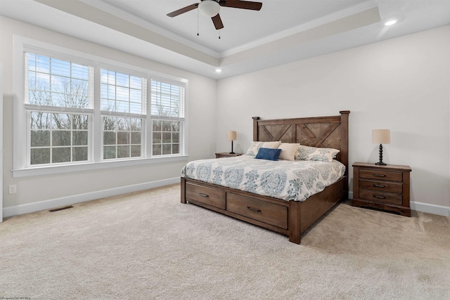 bedroom with light carpet, a raised ceiling, ceiling fan, and crown molding