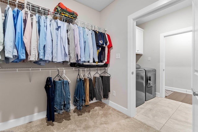 walk in closet featuring washing machine and dryer and light tile patterned flooring