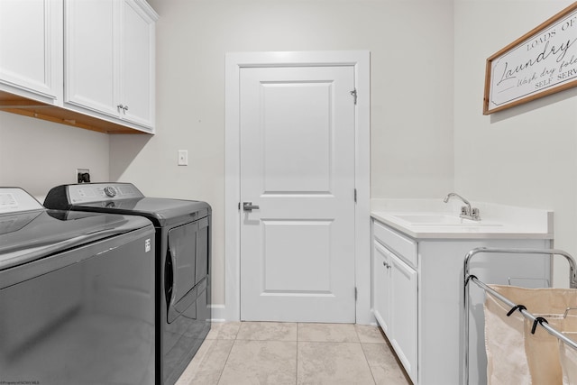 laundry room with cabinets, sink, light tile patterned floors, and washer and dryer