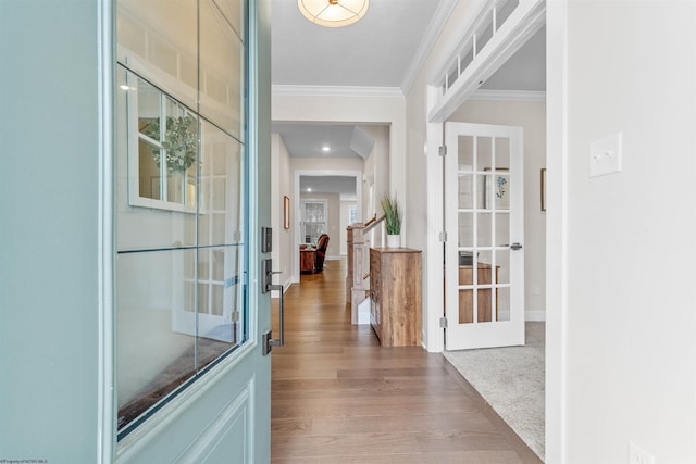 hall featuring light carpet, french doors, and ornamental molding