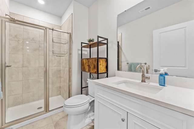 bathroom featuring tile patterned flooring, vanity, a shower with door, and toilet