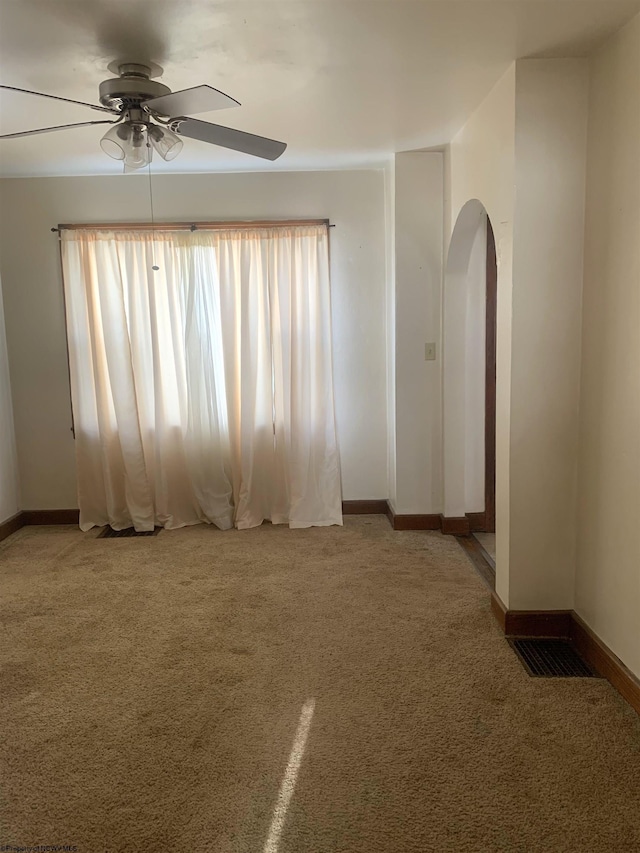 carpeted spare room featuring ceiling fan