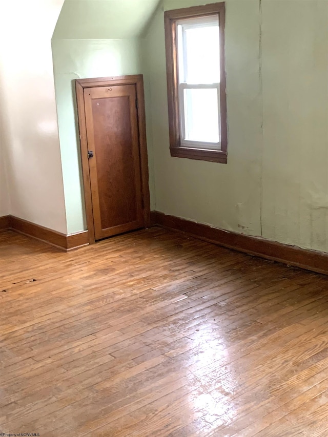 additional living space with lofted ceiling and light hardwood / wood-style flooring