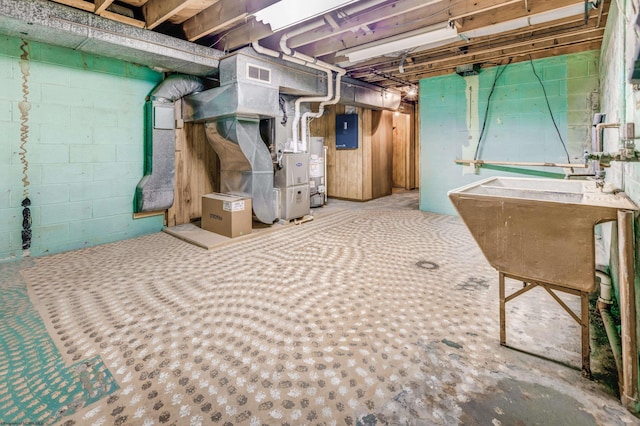 basement featuring electric panel, heating unit, and water heater