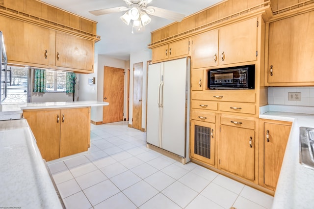 kitchen with kitchen peninsula, backsplash, ceiling fan, white fridge, and light tile patterned flooring