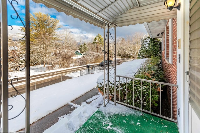 view of snow covered back of property