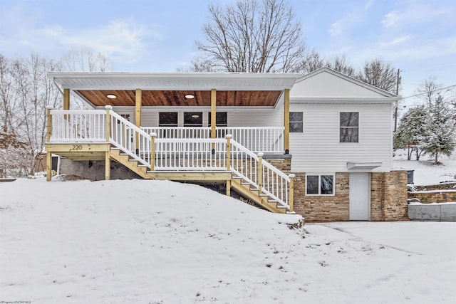 snow covered property featuring covered porch