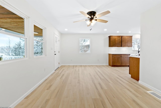 unfurnished living room featuring ceiling fan and light hardwood / wood-style flooring