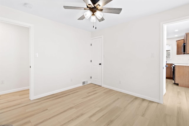 spare room featuring ceiling fan and light hardwood / wood-style floors