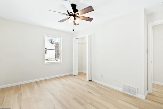 unfurnished bedroom featuring ceiling fan, light wood-type flooring, and a closet