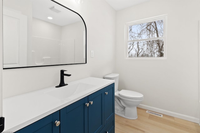 bathroom with wood-type flooring, vanity, and toilet