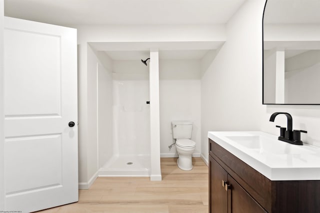 bathroom featuring hardwood / wood-style floors, toilet, a shower, and vanity