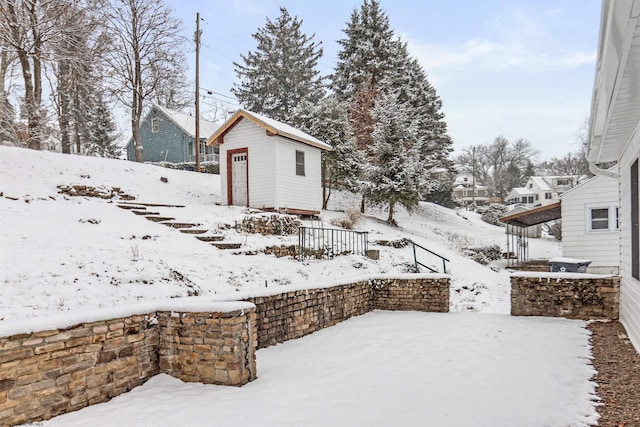 yard layered in snow featuring a storage shed