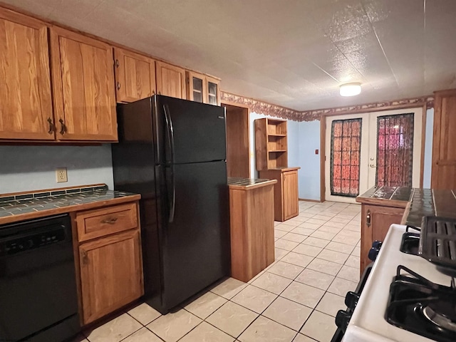 kitchen featuring black appliances, tile counters, and light tile patterned floors