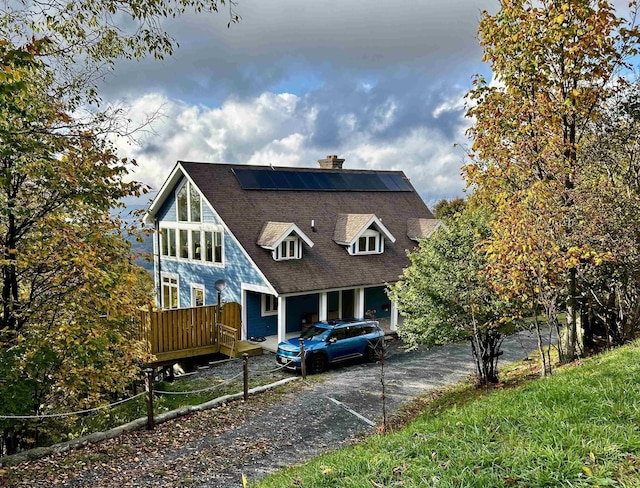 view of front of home featuring solar panels and a deck