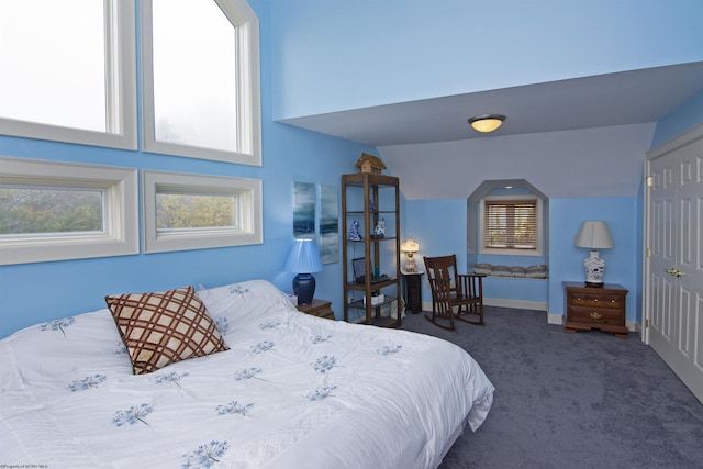 carpeted bedroom featuring multiple windows and lofted ceiling