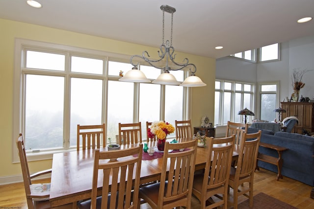 dining space with light hardwood / wood-style flooring and a chandelier