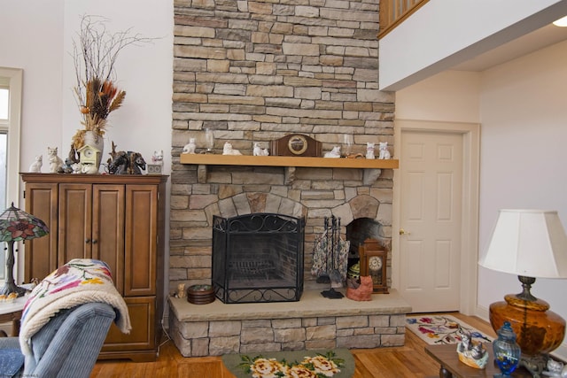 living room with light wood-type flooring and a stone fireplace