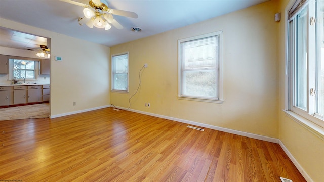 unfurnished room with light hardwood / wood-style flooring, ceiling fan, and sink