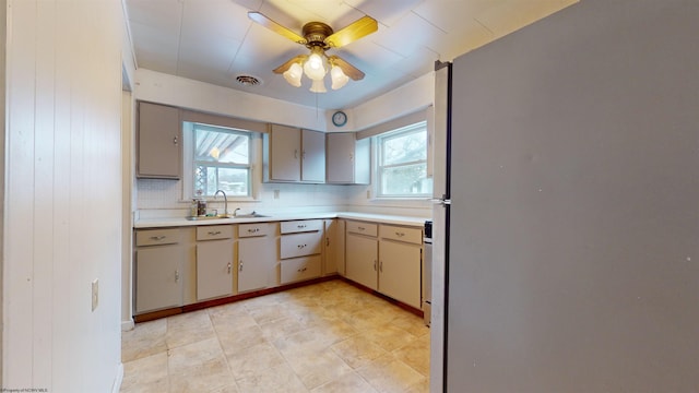 kitchen with plenty of natural light, ceiling fan, sink, and backsplash