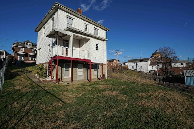 rear view of house featuring a yard