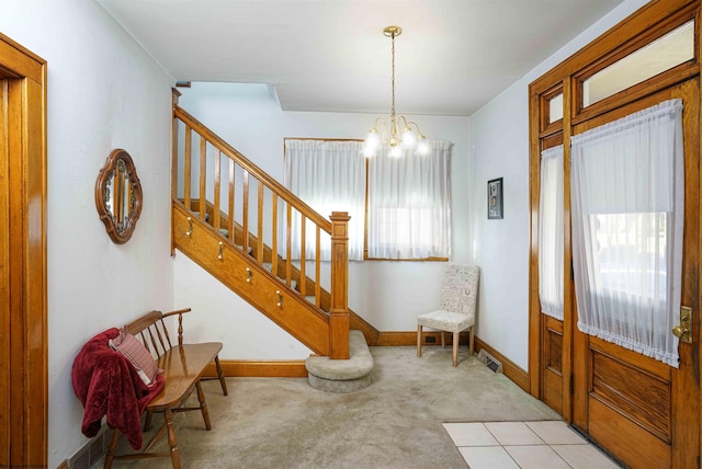 carpeted entrance foyer with a notable chandelier