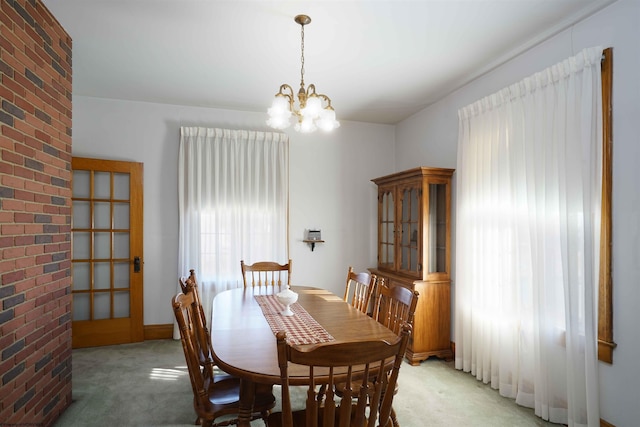 dining room with carpet flooring and a notable chandelier