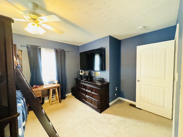 carpeted bedroom with ceiling fan and a textured ceiling