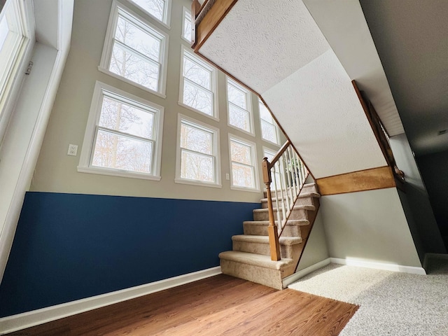 staircase with carpet flooring and a high ceiling