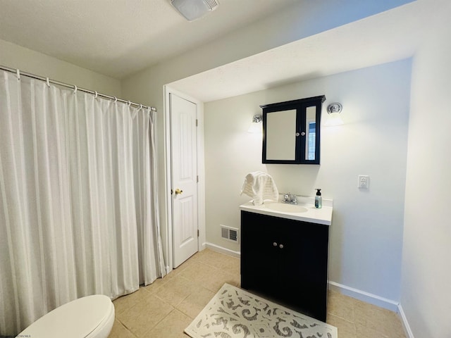 bathroom featuring tile patterned flooring, vanity, and toilet