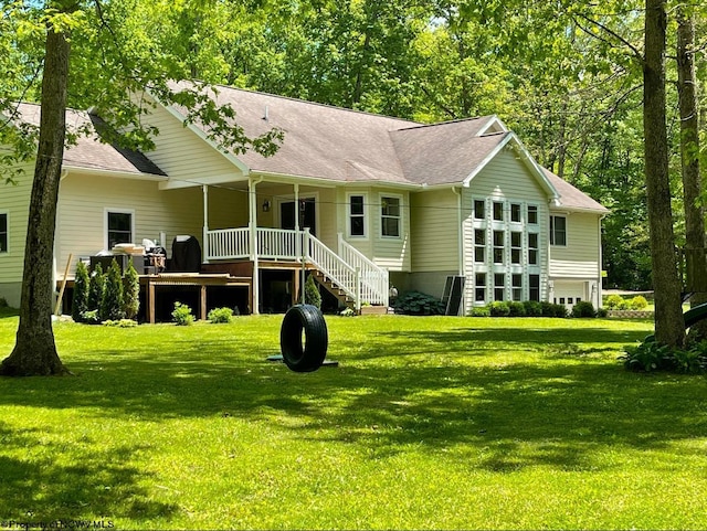 back of property with a lawn and roof with shingles