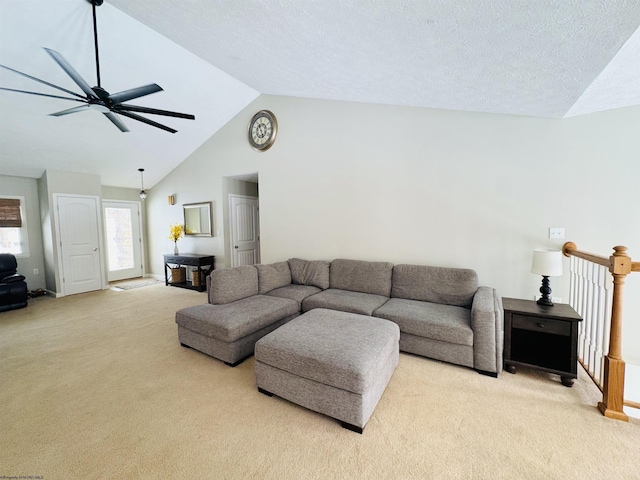 living room featuring a textured ceiling, light colored carpet, ceiling fan, and lofted ceiling