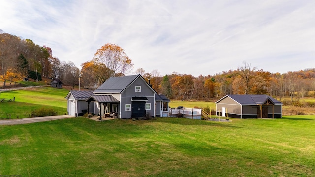 rear view of house featuring an outbuilding and a yard