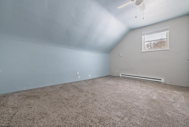 additional living space with carpet flooring, ceiling fan, baseboard heating, a textured ceiling, and vaulted ceiling