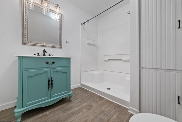 bathroom featuring vanity, toilet, wood-type flooring, and walk in shower