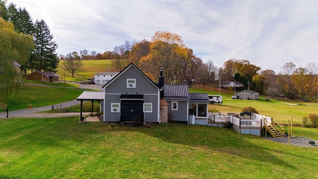 rear view of house featuring a yard, an outdoor structure, and a wooden deck