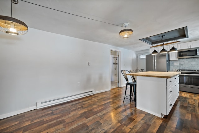 kitchen featuring butcher block counters, a center island, stainless steel appliances, baseboard heating, and white cabinets