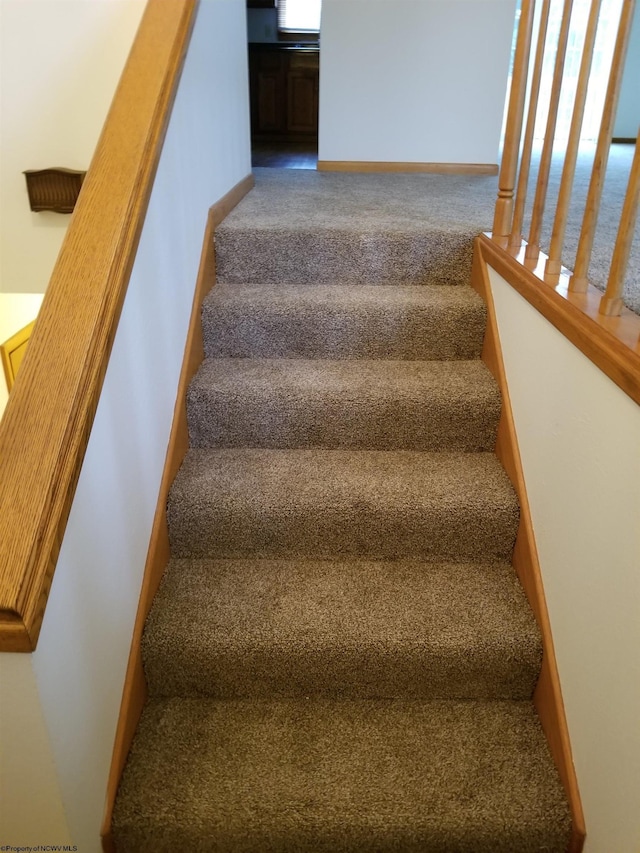 stairs featuring carpet floors and baseboards