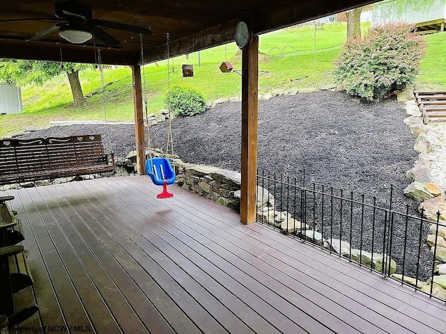 wooden terrace featuring a lawn and ceiling fan