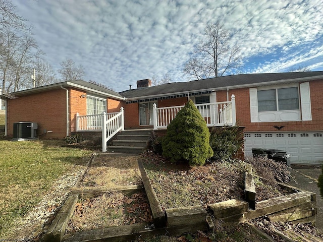 view of front of home with central air condition unit, a porch, and a garage