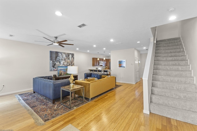 living room with ceiling fan and light hardwood / wood-style floors