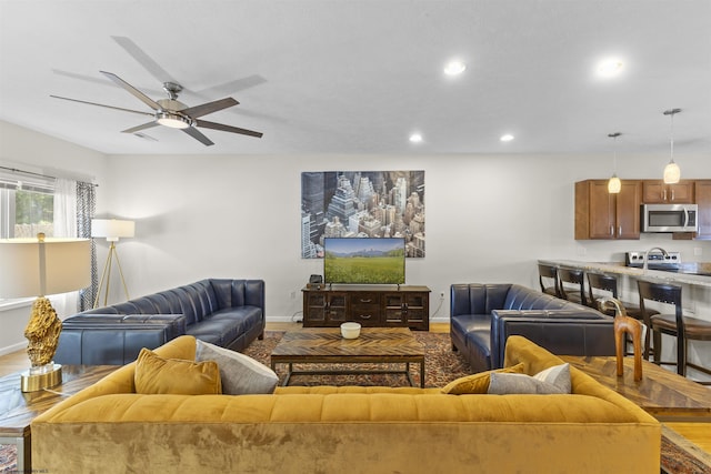 living room featuring ceiling fan and hardwood / wood-style flooring