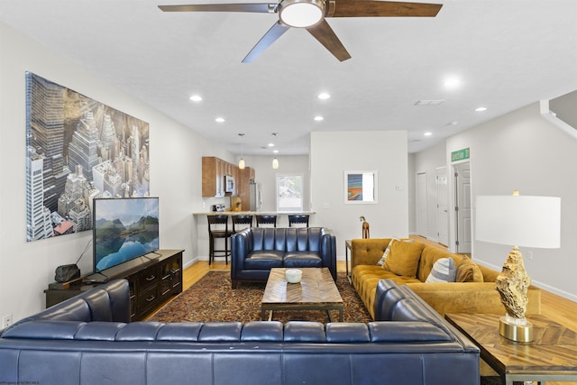 living room featuring wood-type flooring and ceiling fan