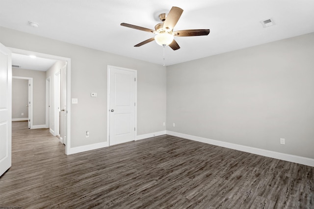 empty room featuring ceiling fan and dark wood-type flooring