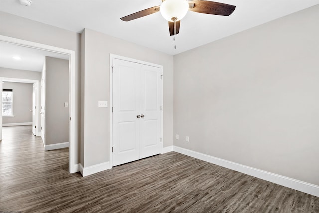 unfurnished bedroom featuring a closet, ceiling fan, and dark wood-type flooring