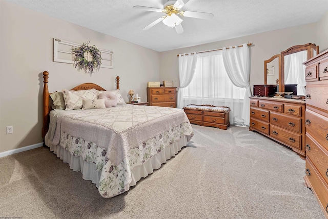 bedroom with a textured ceiling, light colored carpet, and ceiling fan