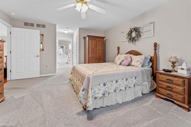 carpeted bedroom featuring ceiling fan, a textured ceiling, and ensuite bath