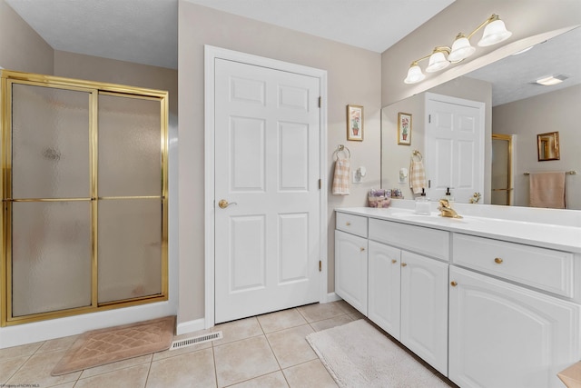 bathroom with tile patterned floors, vanity, and a shower with shower door