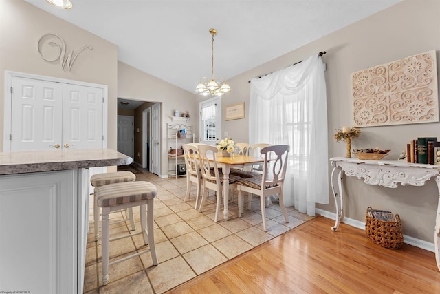 dining area featuring a chandelier, lofted ceiling, and light hardwood / wood-style floors